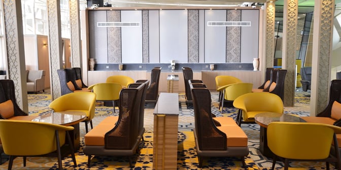 Seating area in the Plaza Premium Lounge at King Abdulaziz International Airport features comfortable chairs and tables for relaxation and work.