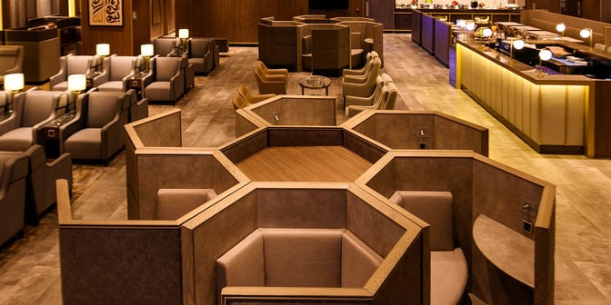 The Plaza Premium Lounge at King Fahd International Airport features hexagonal seating pods and a buffet area for travelers.
