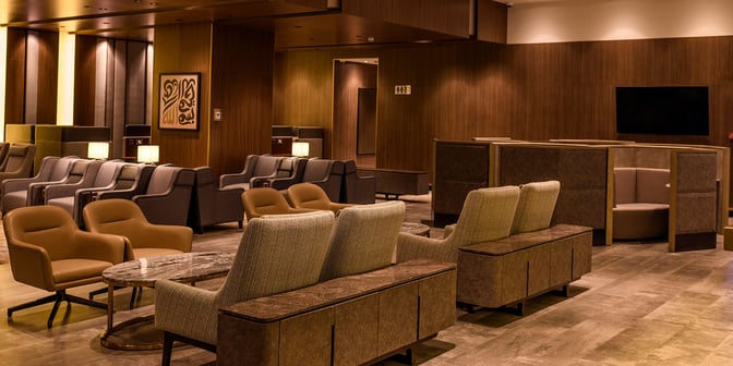 The seating area in the Plaza Premium Lounge at King Fahd International Airport features comfortable chairs and semi-private booths for relaxation.