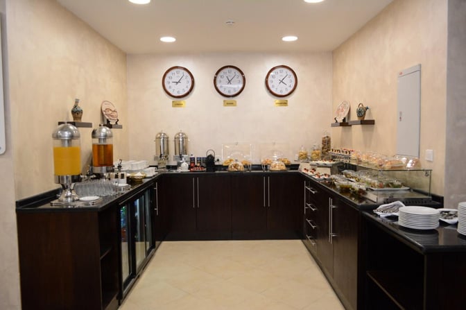 The Pearl Lounge at King Hussein International Airport features a self-serve food area with beverages, pastries, and snacks available.