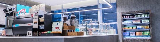 The Flynas Lounge at King Khalid International Airport features a self-serve beverage station with coffee machines and a refrigerated drink display.