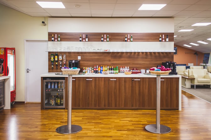 The Kosice Business Lounge features a self-serve beverage station with a variety of drinks and snacks available for guests.