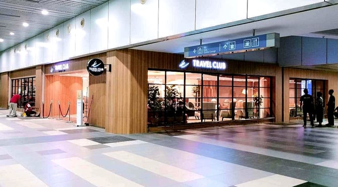 The Travel Club Lounge entrance at Kota Kinabalu International Airport features glass windows and is located in the main terminal area.