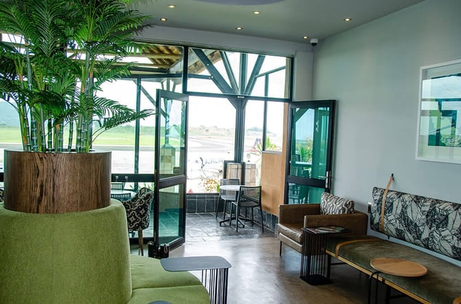 The seating area in the Bidvest Premier Lounge at Kruger Mpumalanga International Airport offers views of the runway through large windows.