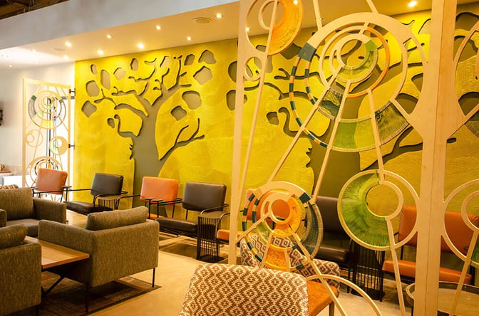 Seating area in the Bidvest Premier Lounge at Kruger Mpumalanga International Airport features comfortable chairs and decorative wall art for relaxation.