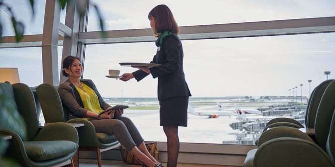 Seating area at Plaza Premium First Lounge, Kuala Lumpur International Airport, offers comfortable chairs with tarmac views and personalized service.