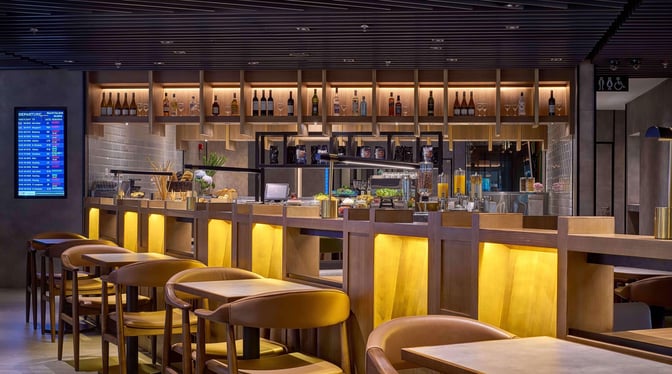 The Plaza Premium Lounge at Kuala Lumpur International Airport features a bar with a variety of beverages and seating options.
