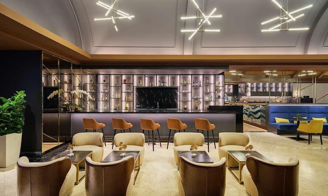 The Sky Suite Airport Lounge at Kuala Lumpur International Airport features a bar with counter seating and a comfortable lounge area.