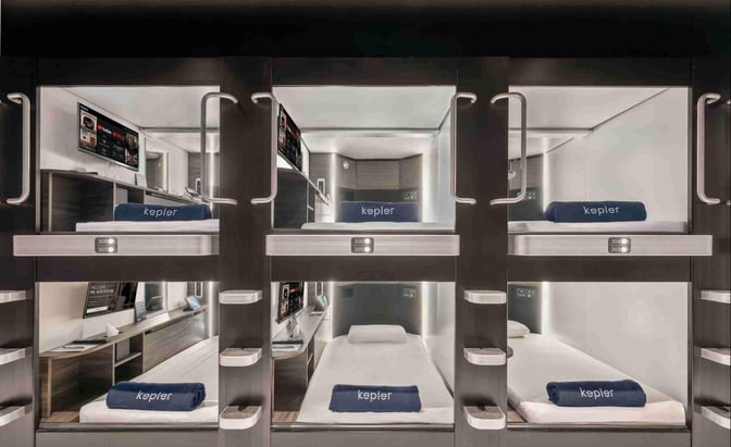 Sleeping pods at Kepler Club in Kuala Lumpur International Airport offer private resting spaces with individual screens and bedding.
