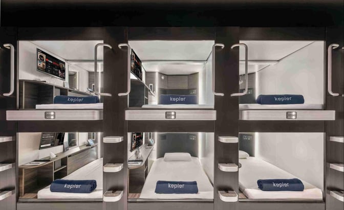 Sleeping pods at Kepler Club in Kuala Lumpur International Airport offer private resting spaces with individual screens and bedding.