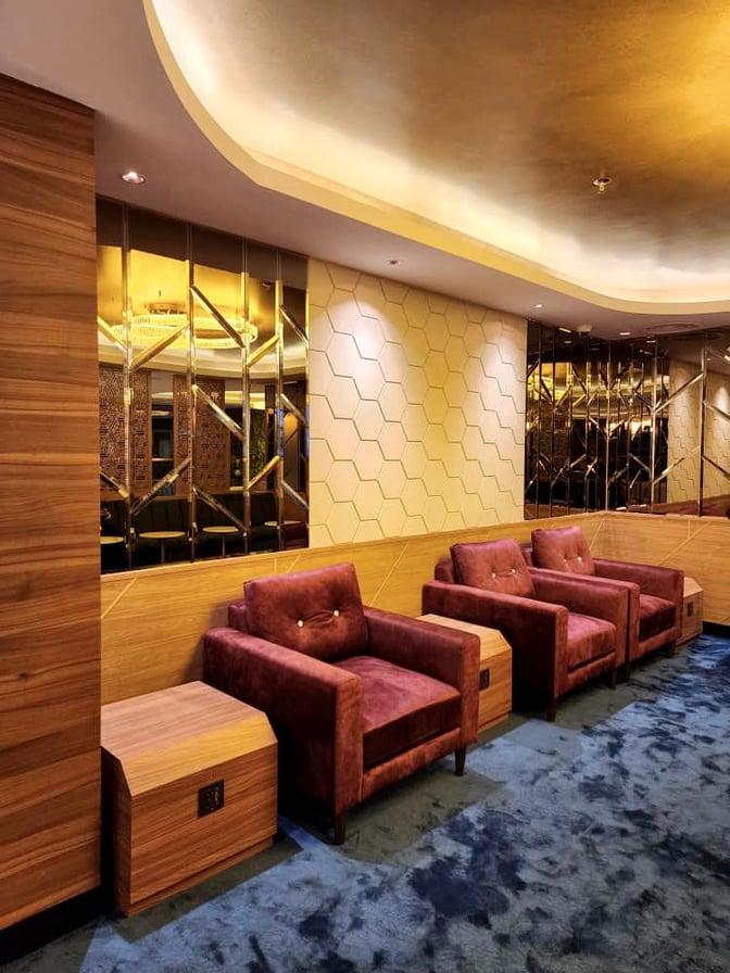 The seating area in the Travel Club Lounge at Kuching International Airport features comfortable armchairs and side tables for travelers.