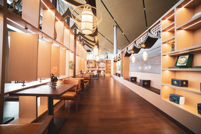 The First Class Lounge V6 at Kunming Changshui International Airport features spacious seating with tables and decorative shelving along the walls.