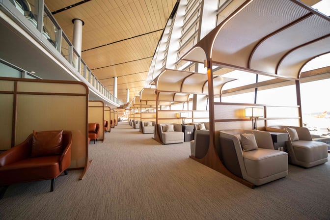 The First Class Lounge V6 at Kunming Changshui International Airport features semi-private seating areas with comfortable chairs and views of the tarmac.