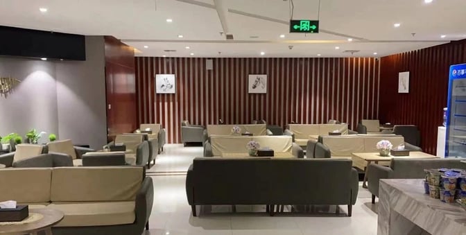 The seating area in the International First Class Lounge at Kunming Changshui Airport features arranged sofas and tables for passenger relaxation.