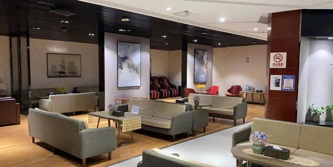 The seating area in the International First Class Lounge at Kunming Changshui Airport features sofas and massage chairs for relaxation.