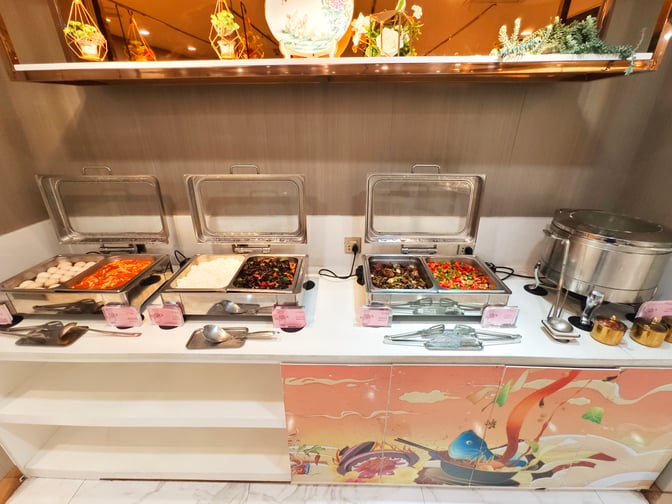 The KunMing Airline V19 Lounge at Kunming Changshui International Airport features a self-serve buffet with various hot food options.