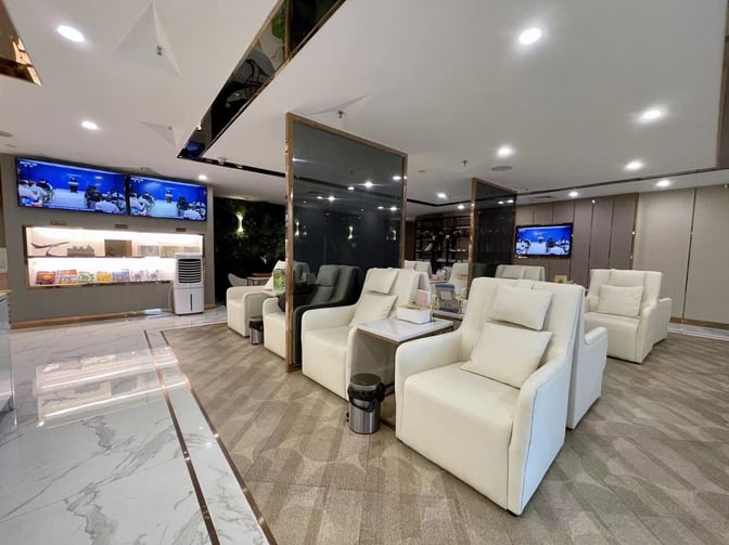 The KunMing Airline V19 Lounge at Kunming Changshui International Airport features comfortable seating with individual tables and multiple television screens.