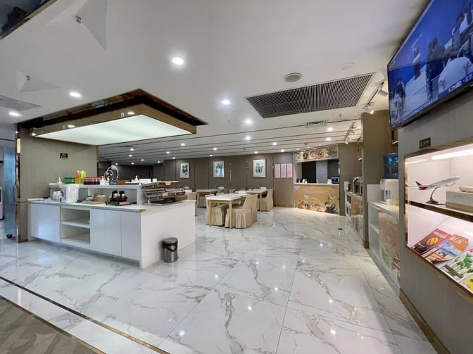 The KunMing Airline V19 Lounge at Kunming Changshui International Airport features a self-serve beverage station and seating area for travelers.