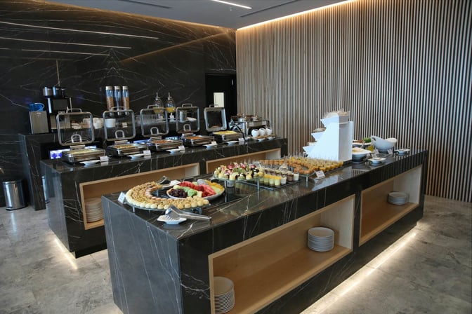 The Al Mubarakiya Lounge at Kuwait International Airport features a self-serve buffet with a variety of hot and cold dishes.