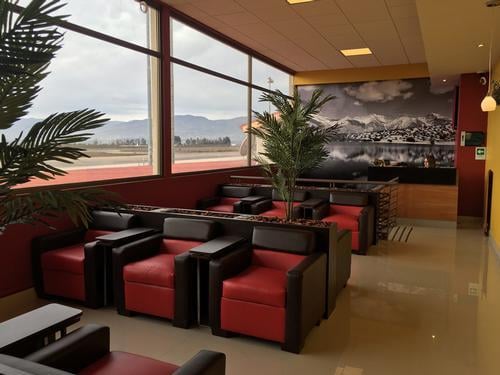The seating area in the Salones VIP Pacific Club at La Florida Airport features armchairs with views of the runway.