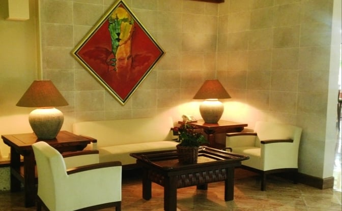 The seating area in Salon Premier at La Romana International Airport features armchairs, a sofa, and side tables with lamps.