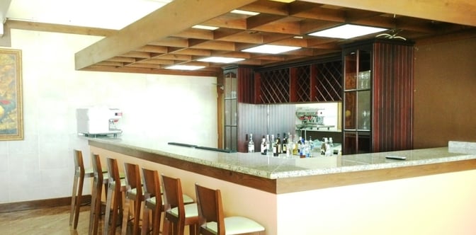 The bar in Salon Premier at La Romana International Airport offers seating and a selection of spirits for travelers.