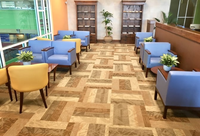 The seating area in Salon Premier at La Romana International Airport features armchairs and small tables, with views of the terminal.
