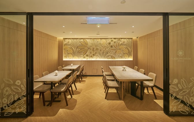 The Plaza Premium Lounge at Langkawi International Airport features a private dining area with multiple tables and chairs for group seating.