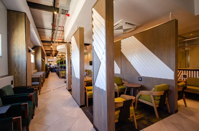 The Bidvest Premier Lounge at Lanseria International Airport features semi-private seating areas with tables, offering a comfortable space for travelers.