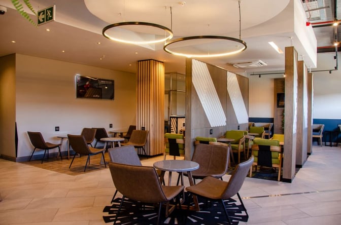 The seating area in the Bidvest Premier Lounge at Lanseria International Airport features various chairs and tables for travelers to relax.