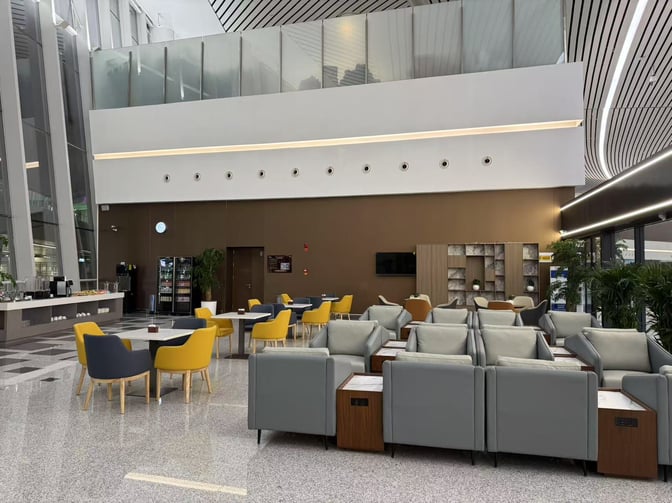 The T3 VIP Lounge at Lanzhou Zhongchuan Airport features comfortable seating, a self-serve beverage station, and a dining area with tables.