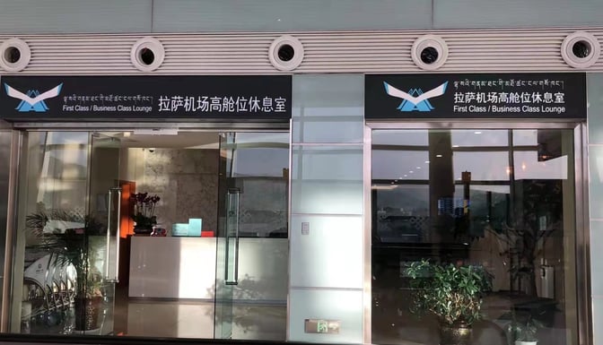 The entrance to the First Class/Business Class Lounge at Lhasa Gonggar Airport features glass doors and a reception area.