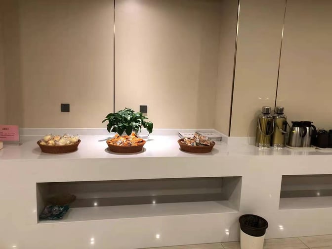 Self-serve snack station in the First Class Lounge at Lhasa Gonggar Airport offers packaged snacks and hot beverage dispensers.