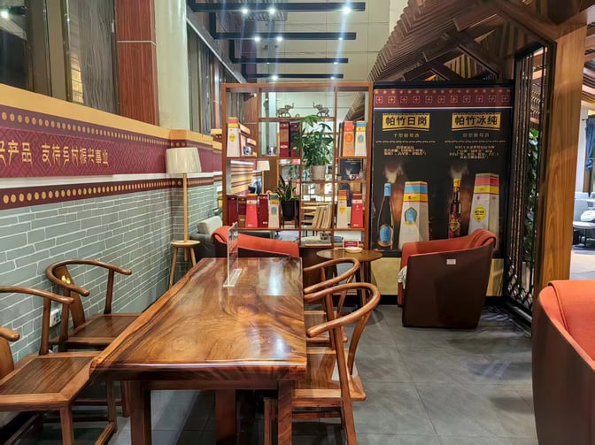 The VIP lounge at Lijiang Sanyi Airport features a seating area with wooden tables and chairs, offering a cozy atmosphere.