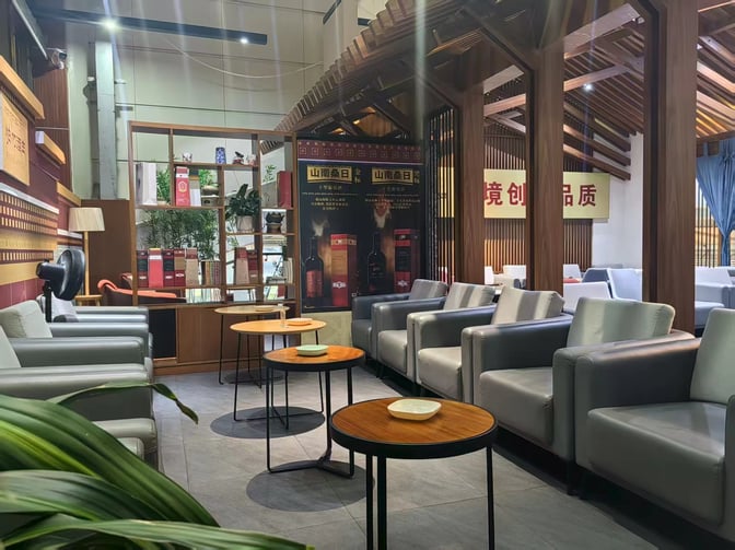 The seating area in Lijiang Sanyi Airport's VIP Lounge features comfortable armchairs and small tables, providing a relaxing space for travelers.
