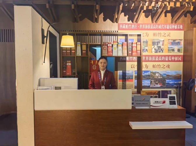 The reception desk at Lijiang Sanyi Airport's VIP Lounge features informational displays and welcomes Lounge Club members.