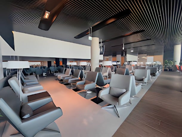The ANA Airport Lounge at Lisbon Portela Airport features spacious seating areas with individual chairs and tables for travelers.