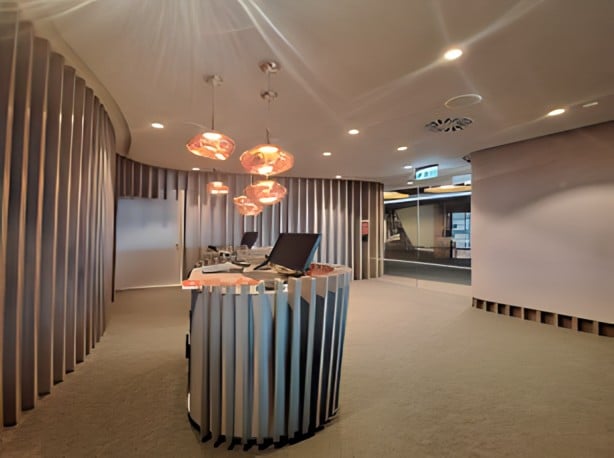 The ANA Airport Lounge entrance at Lisbon Portela Airport features a reception desk with hanging lights and a view of the terminal.