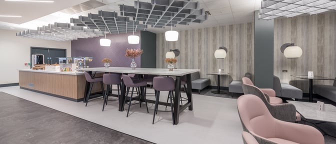 The Aspire Lounge at Liverpool John Lennon Airport features a high-top table with bar stools and a self-serve refreshment area.