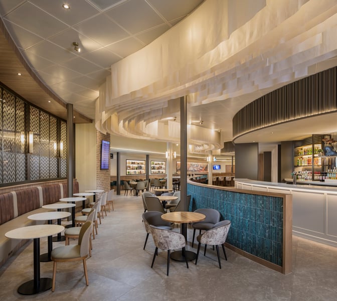 The Aspire Lounge at Liverpool John Lennon Airport features a bar with a variety of beverages and seating areas for relaxation.