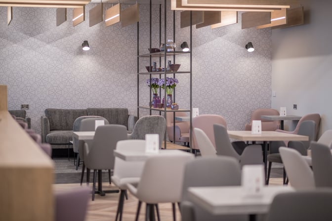 The Aspire Lounge at Liverpool John Lennon Airport features a seating area with tables and chairs, providing a comfortable space for travelers.