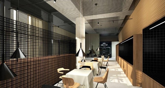 The dining area in Ljubljana Airport's business lounge features tables with chairs and hanging lights, offering a space for meals.