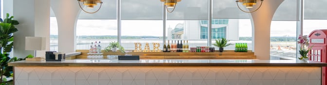 The bar at Plaza Express Lounge in London Gatwick Airport offers a selection of wines, spirits, and soft drinks with counter seating.