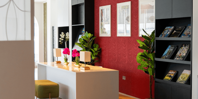 The Plaza Express lounge at London Gatwick Airport features a reading area with bookshelves, decorative plants, and a seating counter.