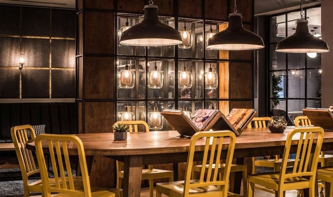 The communal table in My Lounge at London Gatwick Airport features magazines and seating, ideal for group gatherings or solo travelers.