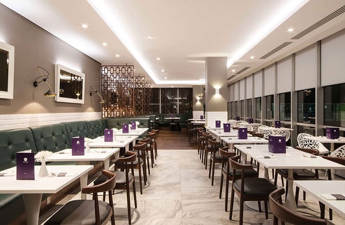 The No1 Lounge at London Gatwick Airport features a dining area with tables, chairs, and booth seating for travelers.