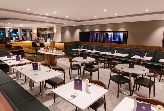 The No1 Lounge at London Gatwick Airport features a dining area with table seating and a bar offering refreshments.