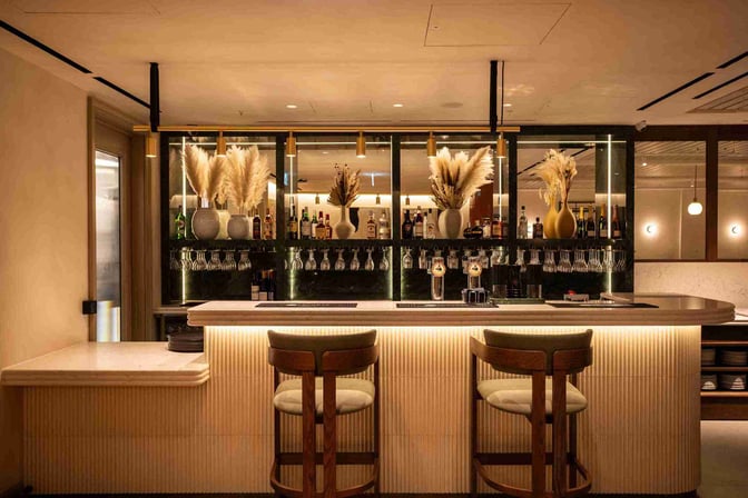 The bar at No1 Lounge, London Heathrow Airport, features a selection of spirits and wines with seating for guests.
