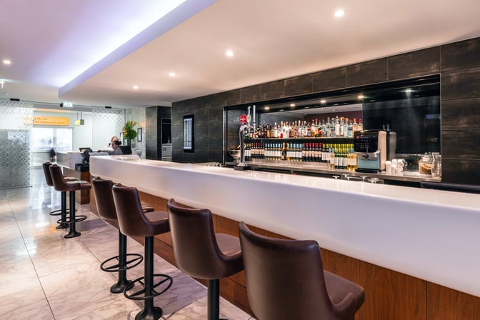 The No1 Lounge at London Heathrow Airport features a bar with a selection of spirits, wines, and seating for travelers.