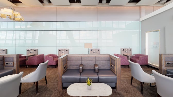 The Club Aspire Lounge at London Heathrow features booth seating with individual power outlets and small tables for travelers.